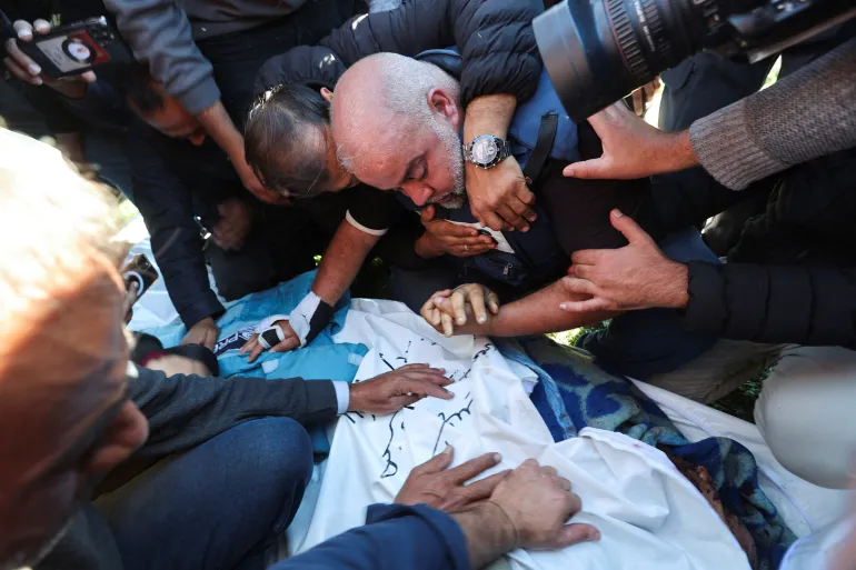 Al Jazeera journalist Wael Dahdouh reacts as he attends the funeral of his son