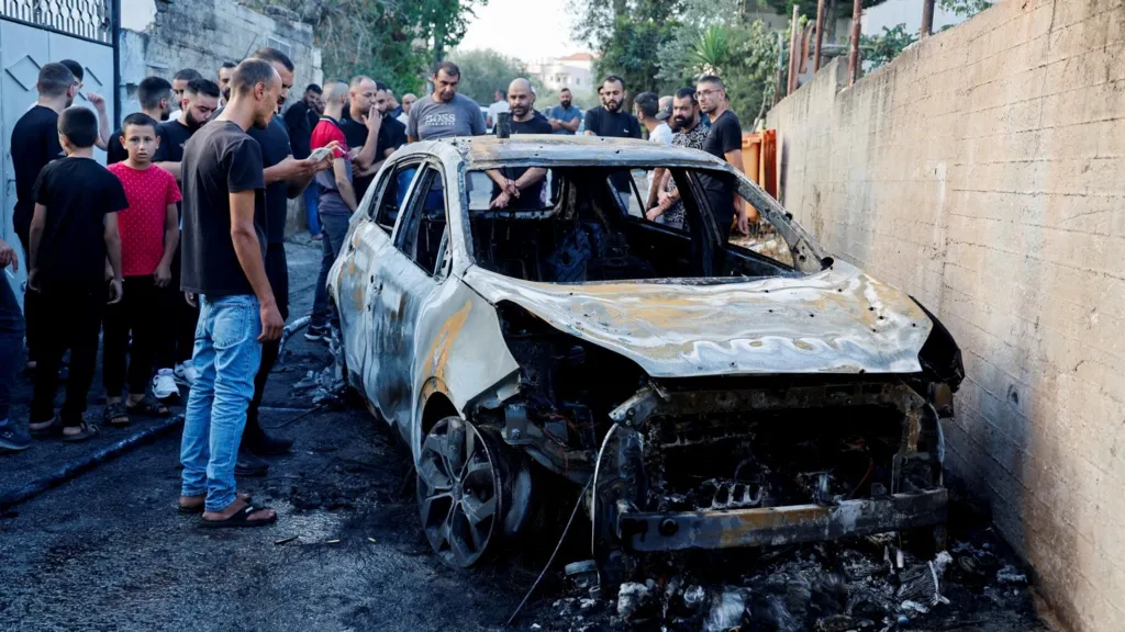 The destroyed vehicle that was carrying the three men