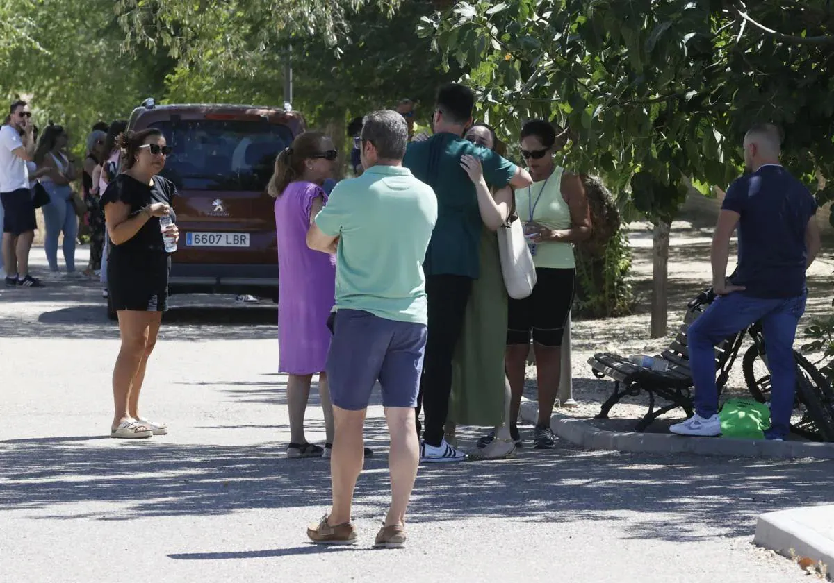 Family and friends gather at the murder scene