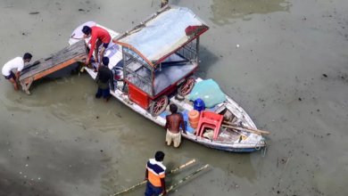 Flood affected residents move their belongings on a boat following heavy monsoon rains in the indian city of Prayagraj