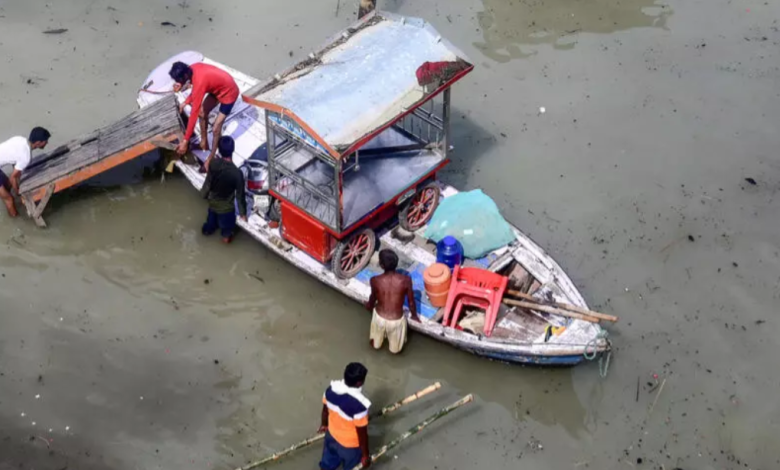 Flood affected residents move their belongings on a boat following heavy monsoon rains in the indian city of Prayagraj