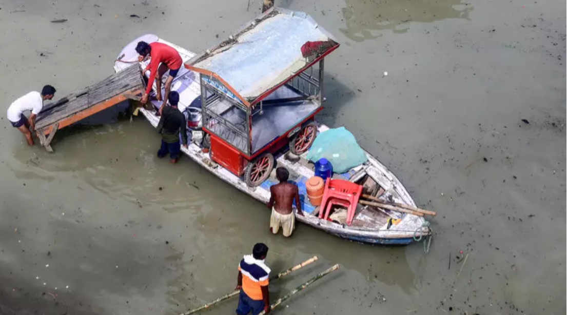 Flood affected residents move their belongings on a boat following heavy monsoon rains in the indian city of Prayagraj