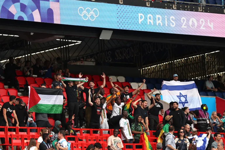 Fans hold the Palestinian and Israeli nationals flags