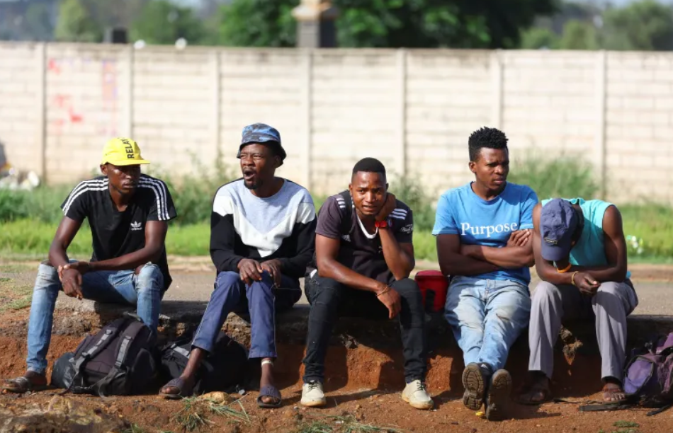 Job seekers wait beside a road in Eikenhof ,south of Johannesburg