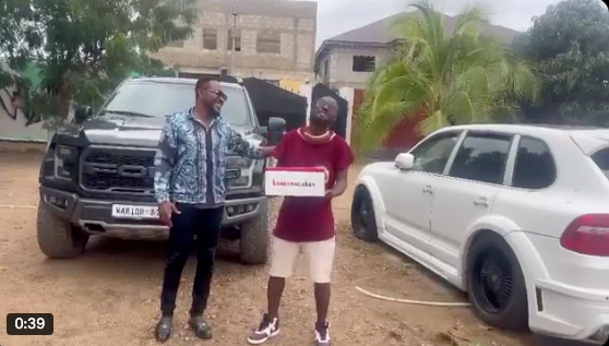 Baffour Gyan presenting a birthday cake to Funny Face