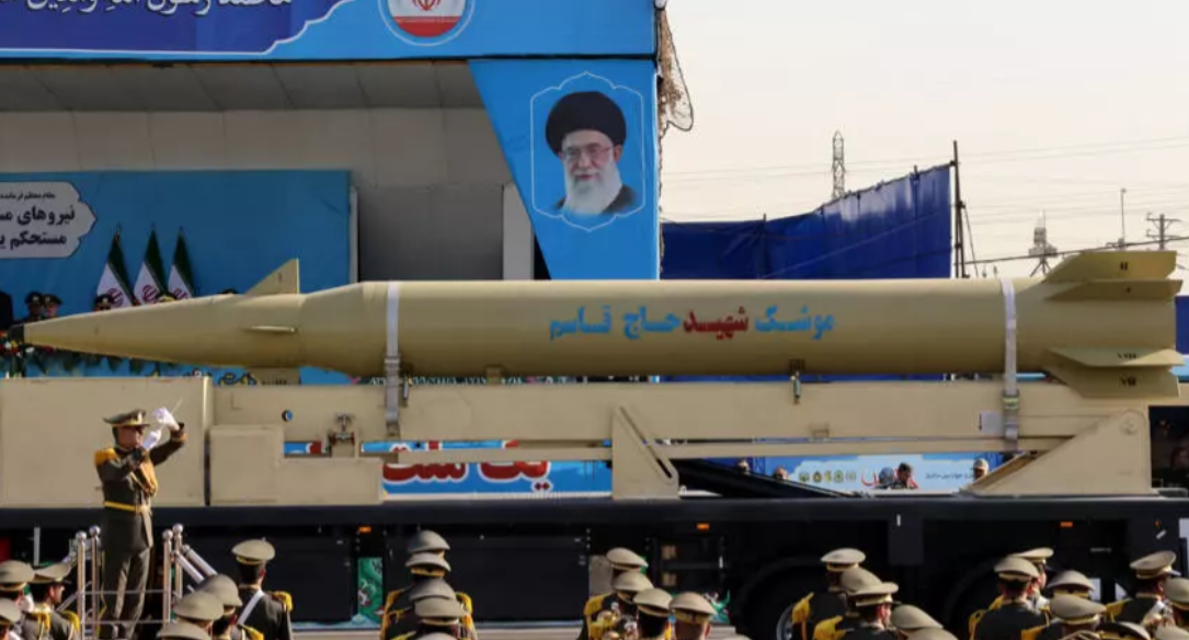 Iran's president looks on as a Qasem Soleiman missile is display during annual military parade