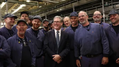 Keir Starmer with employee for photographer during a visit to a factory in Chester