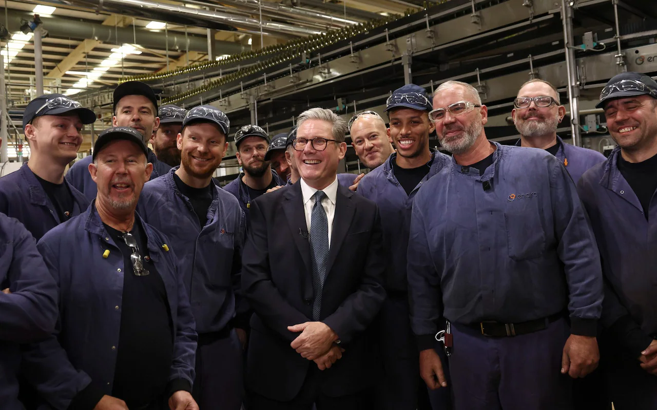 Keir Starmer with employee for photographer during a visit to a factory in Chester