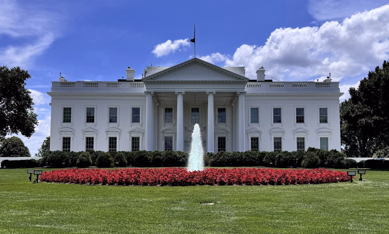A contemporary colour view of the White House’s north façade in Washington, DC, showing its white neoclassical portico, columns, North Lawn fountain and landscaped grounds.