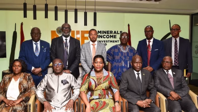 A group of formally dressed people pose for a photograph indoors in front of a Minerals Income Investment Fund sign.