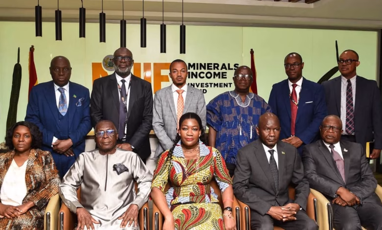 A group of formally dressed people pose for a photograph indoors in front of a Minerals Income Investment Fund sign.