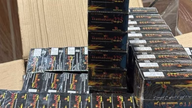 Stacks of black boxed products are arranged on a table or counter indoors.