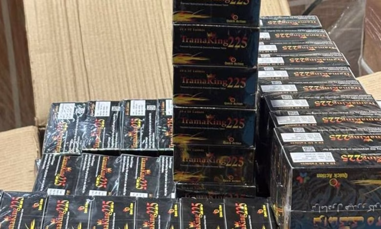Stacks of black boxed products are arranged on a table or counter indoors.