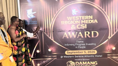 Several people stand beside a large event display for the Ghana Journalists Association Western Region Media and CSI Award.